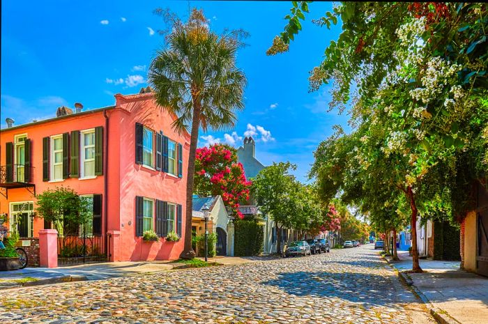 A charming cobblestone street adorned with pastel-hued historic homes