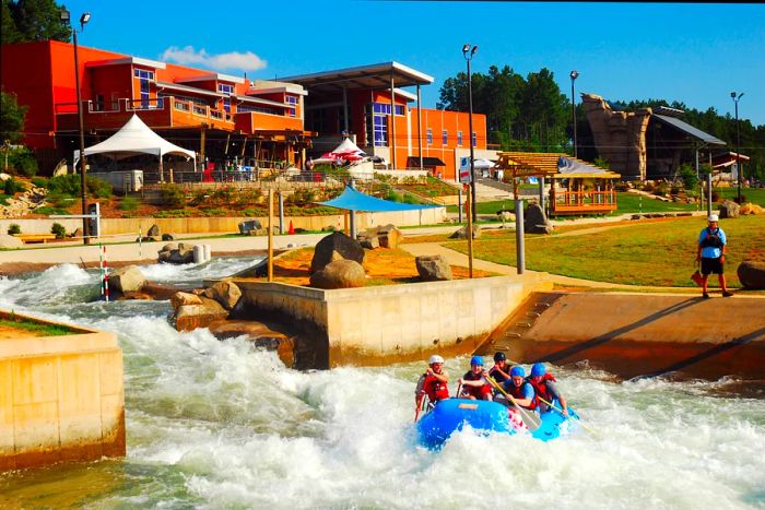 Enjoying white water rafting at a sports center on a bright day