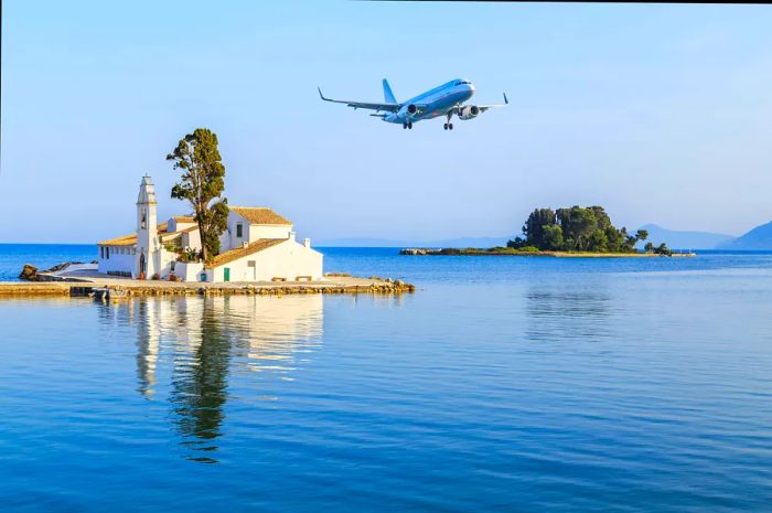 A plane descends over the Vlacherna Monastery in Kerkyra, Corfu, Greece