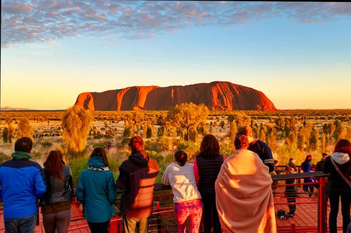 Visitors admire Uluru at sunset, Red Centre, Northern Territory, Australia