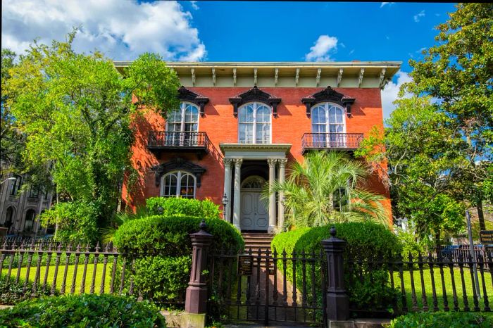 A historic red brick home with columns in Savannah, Georgia