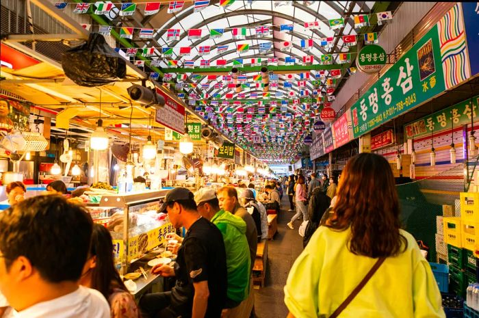 Visitors stroll past vendor stalls at Gwangjang, a bustling food market in Seoul, South Korea