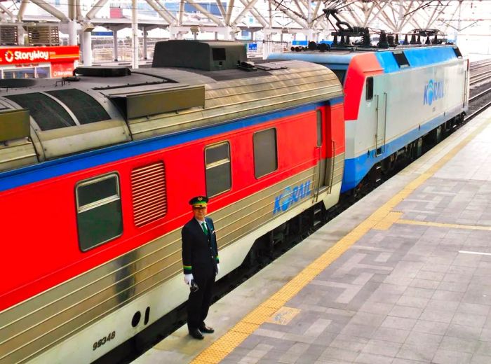 A conductor stands on a platform at a train station in Seoul, South Korea