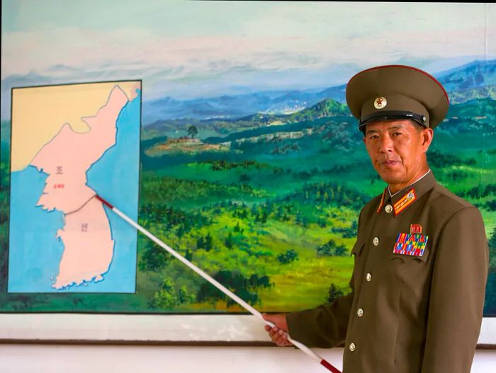 A North Korean Colonel gestures at a map of the Korean DMZ.