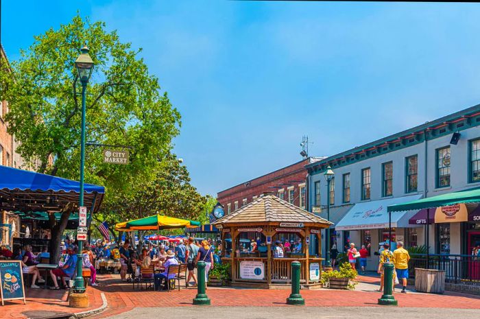 A lively pedestrian street adorned with shops and eateries, where diners enjoy meals at outdoor tables