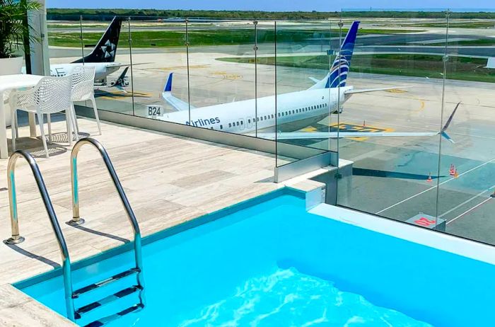 The right credit cards can grant you access to premier lounges, like the Priority Pass lounge at Punta Cana Airport, where you can relax by a pool while waiting to board your flight.