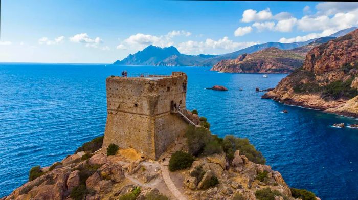 Aerial view of the remnants of the square Genoese tower in Porto, located at the end of the Gulf of Porto, Corsica, France.