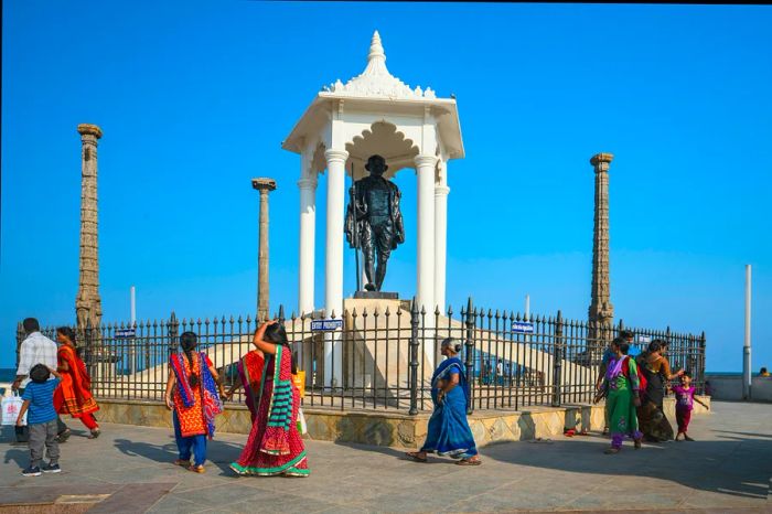 Visitors stroll past the Gandhi Memorial located along the beachfront promenade in Pondicherry, India.