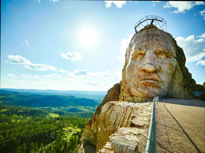 A monumental stone carving depicting a head and face on a hillside