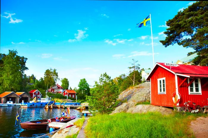 Charming boat houses line the harbor in the picturesque hamlet of Bruket, located on the lush Stockholm peninsula.