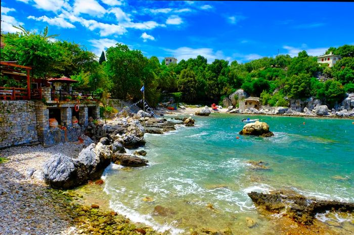 Stone structures line the shore of a light blue coastline.