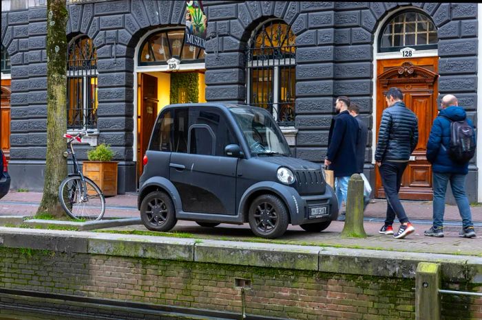 A MOVE CityCar, a sleek small electric vehicle, parked outside the Hash Marihuana Museum in Amsterdam