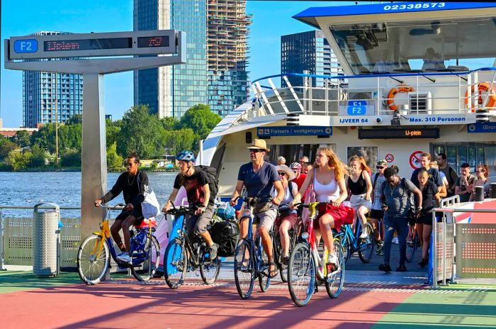 Bicyclists disembarking from a shuttle ferry service along the waterfront in Amsterdam, Netherlands