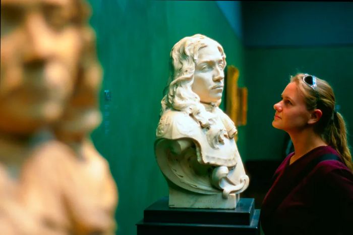 A woman admiring a bust in the Rijksmuseum.