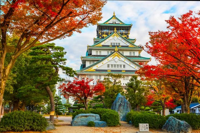 A multi-level castle surrounded by vibrant autumn foliage