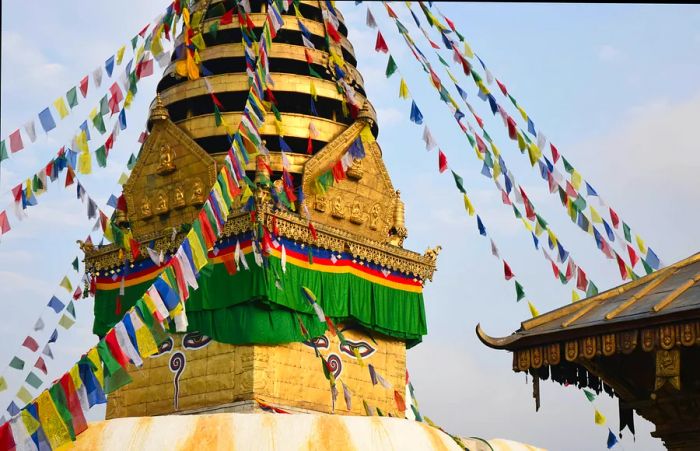 A golden stupa adorned with vibrant prayer flags