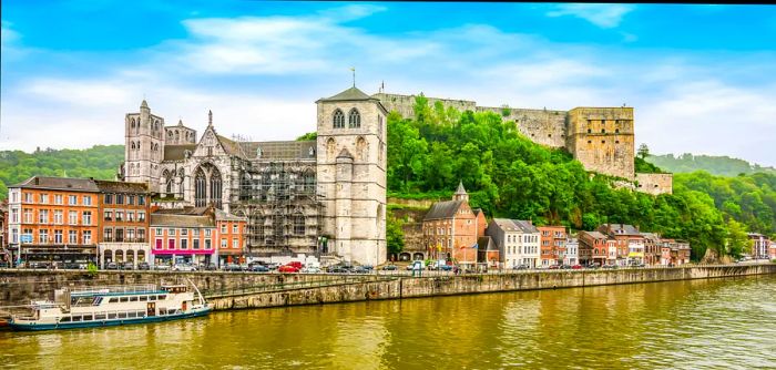 A fortress towers over a riverside town from its hilltop vantage point.