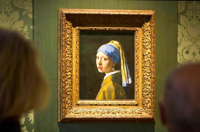 Visitors admire Vermeer’s “Girl with a Pearl Earring” at the Mauritshuis museum in The Hague, Netherlands