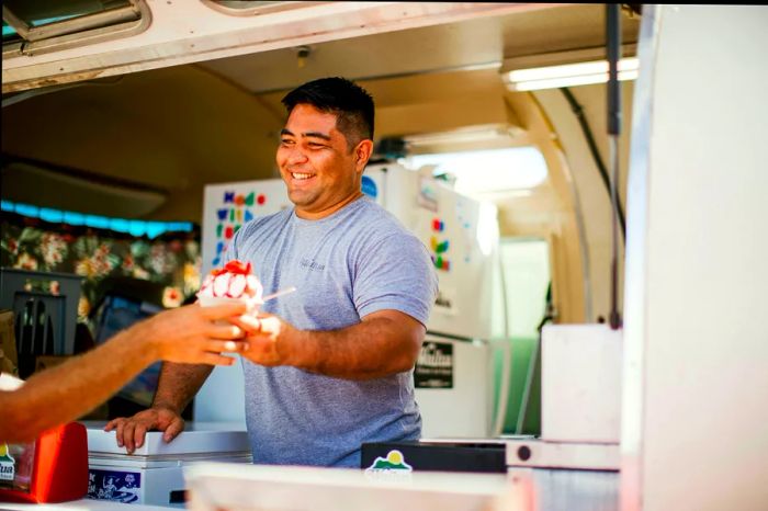 Chef Brandon Baptiste serves shave ice to a customer in Kauai