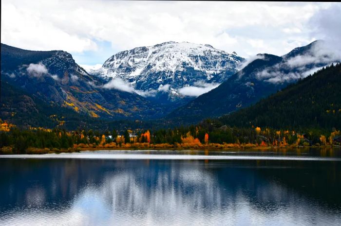 The stunning reflection of mountains and trees mirrored in a lake in the Rocky Mountains.