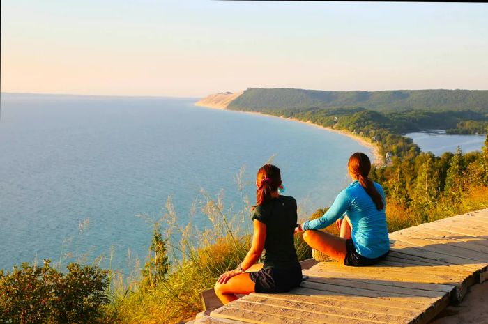 Visitors basking in the stunning sunset views at the Empire Bluff Scenic Lookout, which provides a breathtaking view of Lake Michigan, the Sleeping Bear Dunes, and Manitou Island.