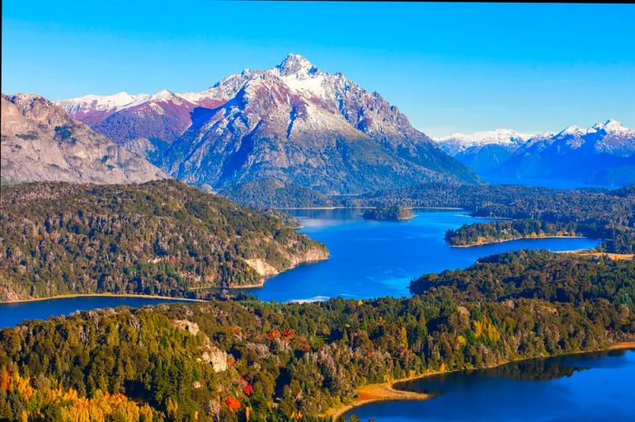 A serene mountain lake dotted with islands shrouded in lush forests