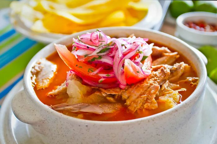 Encebollado: a delightful fish stew served with banana chips and a splash of lemon.