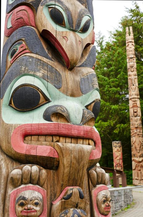 A carved wooden totem pole featuring intricate faces