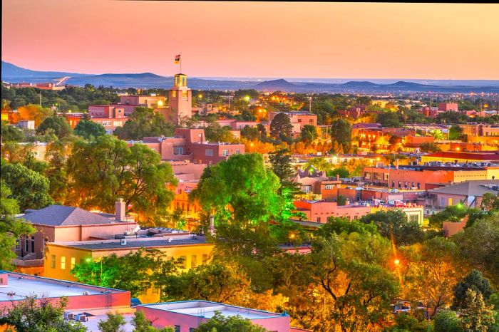 A low-rise city skyline bathed in the warm orange hues of sunset