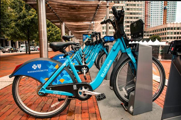 A line of uniform blue bikes available for rental from street stations