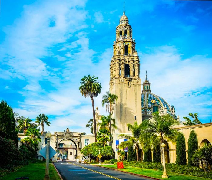 A structure featuring a tall bell tower set within beautifully landscaped grounds