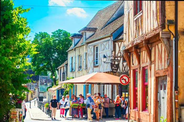 Visitors stroll next to medieval structures in Provins, France