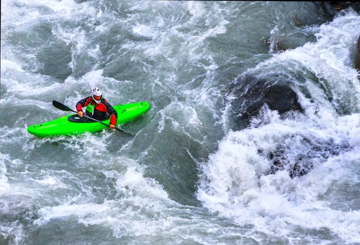 A kayaker navigating the white waters of the Kali Gandaki River, near Tatopani, in the Annapurna Conservation Area, Sindhupalchok District, Nepal