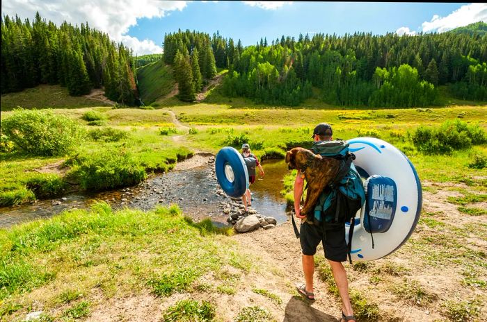 A couple makes their way to a lake with water tubes near Crested Butte, Colorado