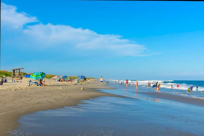 People enjoying a sunny day at the beach, relaxing and playing on the sand