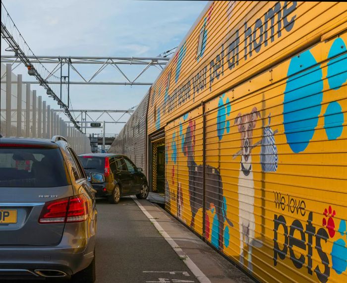 Two cars are getting ready to board a Eurotunnel train.