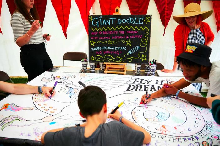 A glimpse of festival-goers engaged in creative activities within a tent at the End of the Road Festival in 2023