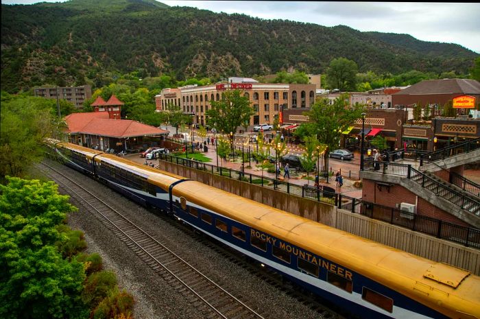 A train parked in a town nestled among mountains