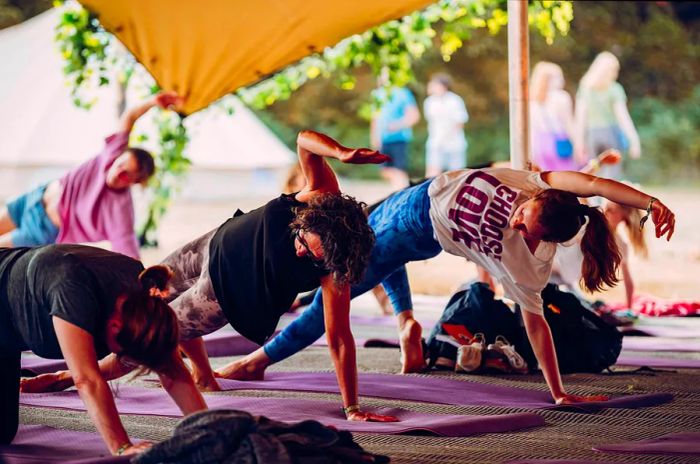 Attendees practicing yoga in a bell tent at Latitude music festival, UK