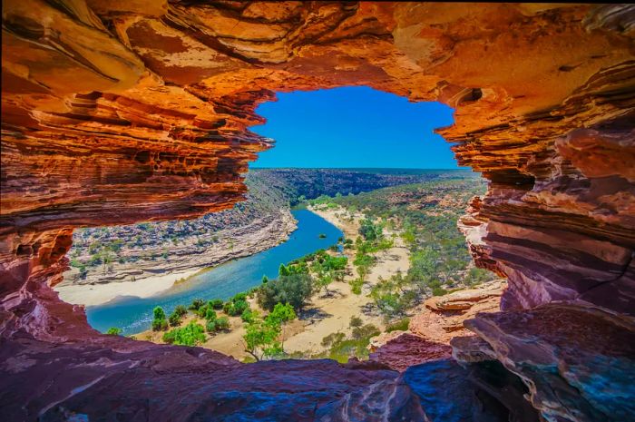 A river flows through a gorge featuring striking red-rock formations