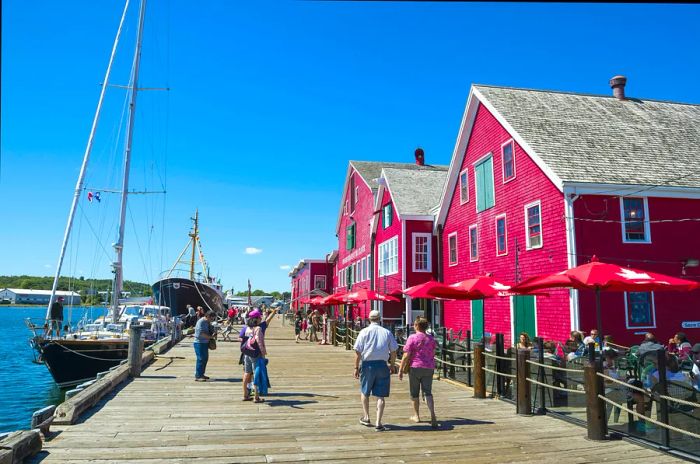 Visitors wander along the charming wooden boardwalk in front of the iconic wooden buildings of the UNESCO World Heritage British colonial settlement.