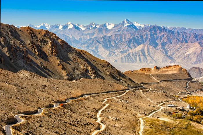 A winding mountain road twists and turns through hilly terrain