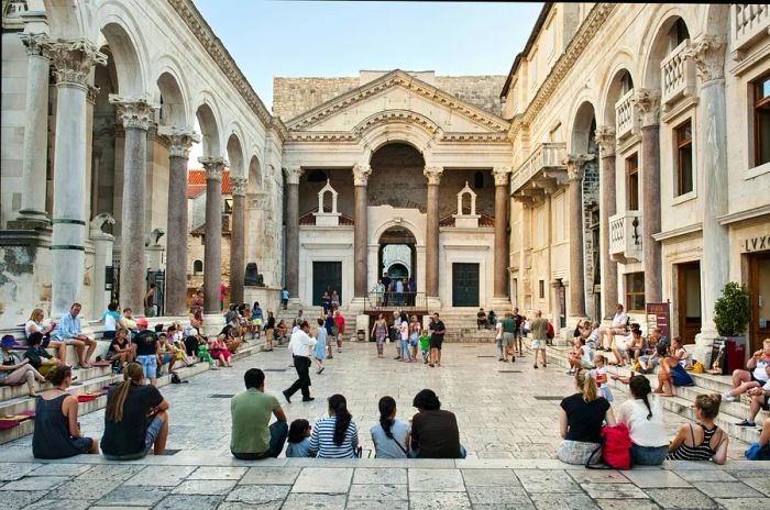 A Roman temple bustling with groups of visitors