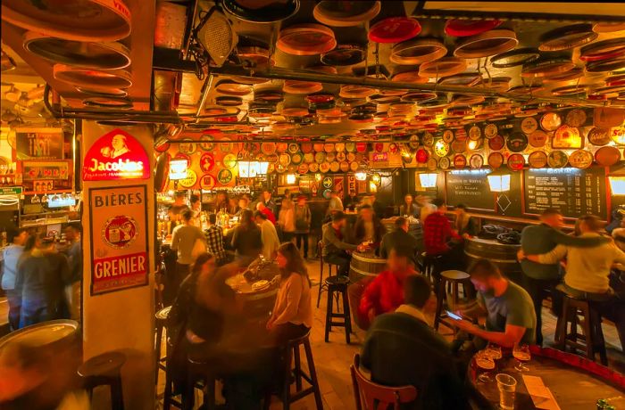 Patrons enjoying beers at the atmospheric Delirium Café in Brussels, Belgium.