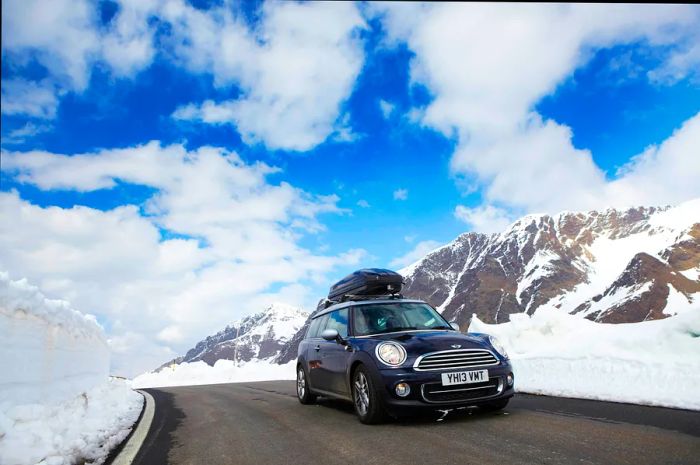 A mini vehicle navigating a snow-covered road in Switzerland.