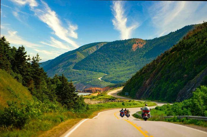 Motorcycles cruising along the Cabot Trail in Cape Breton Highlands National Park, Nova Scotia, Canada on a sunny summer day