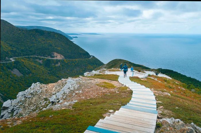 Visitors stroll along the Skyline Trail above the ocean in Cape Breton Highlands National Park, Nova Scotia, Canada