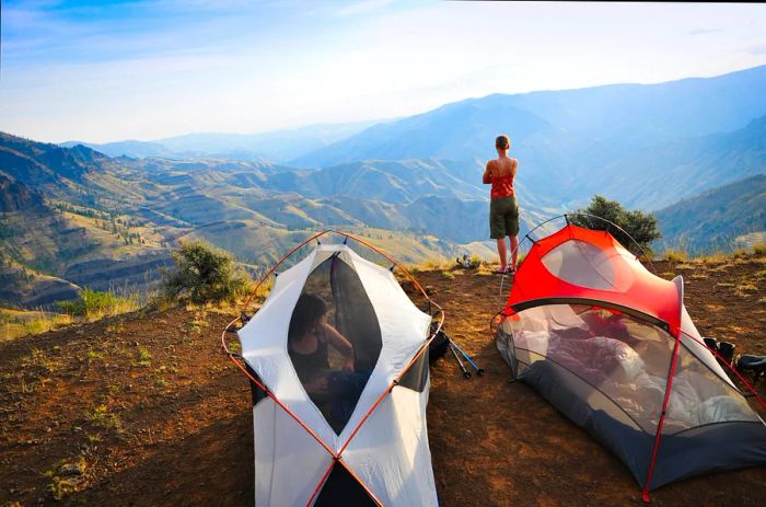 A hiker enjoys the scenic view of Hells Canyon from her campsite during a backpacking trip.