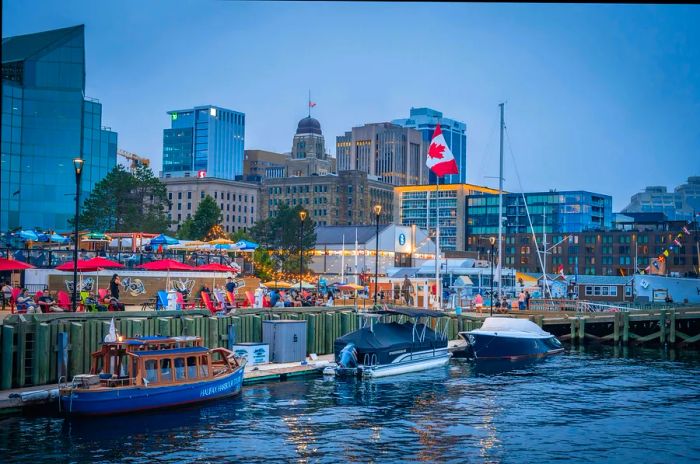 The scenic waterfront boardwalk against the backdrop of the city skyline on a summer evening in Halifax, Nova Scotia, Canada