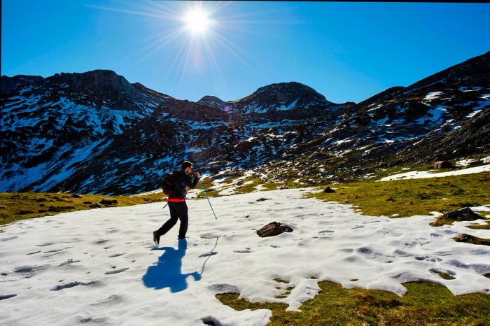 A hiker traversing a snowy trail in Parque Natural de Somiedo, Asturias, Spain